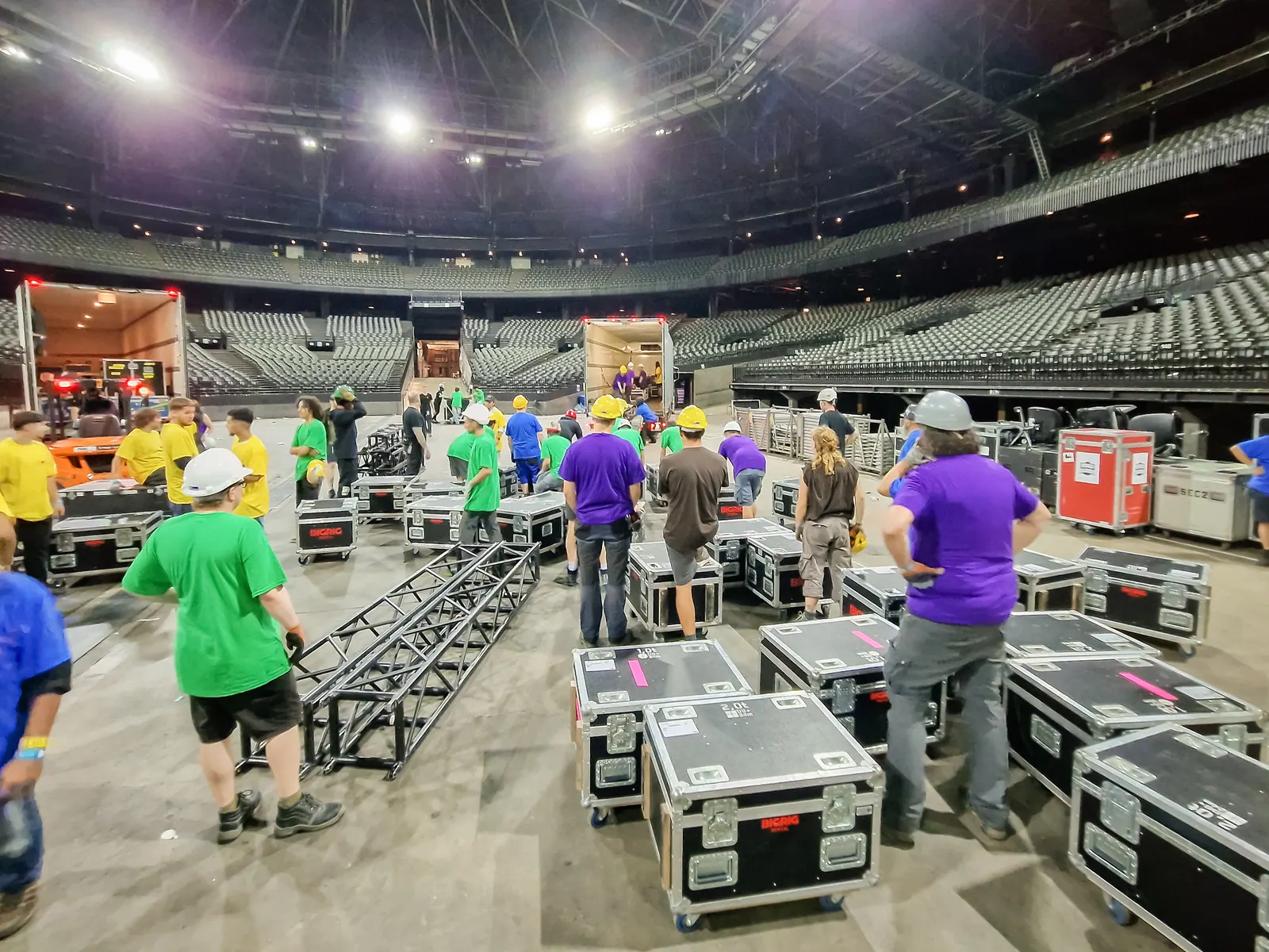 Hands 4 Events crew on the floor during arena load-out — bigrig, truss, colour-coded crew